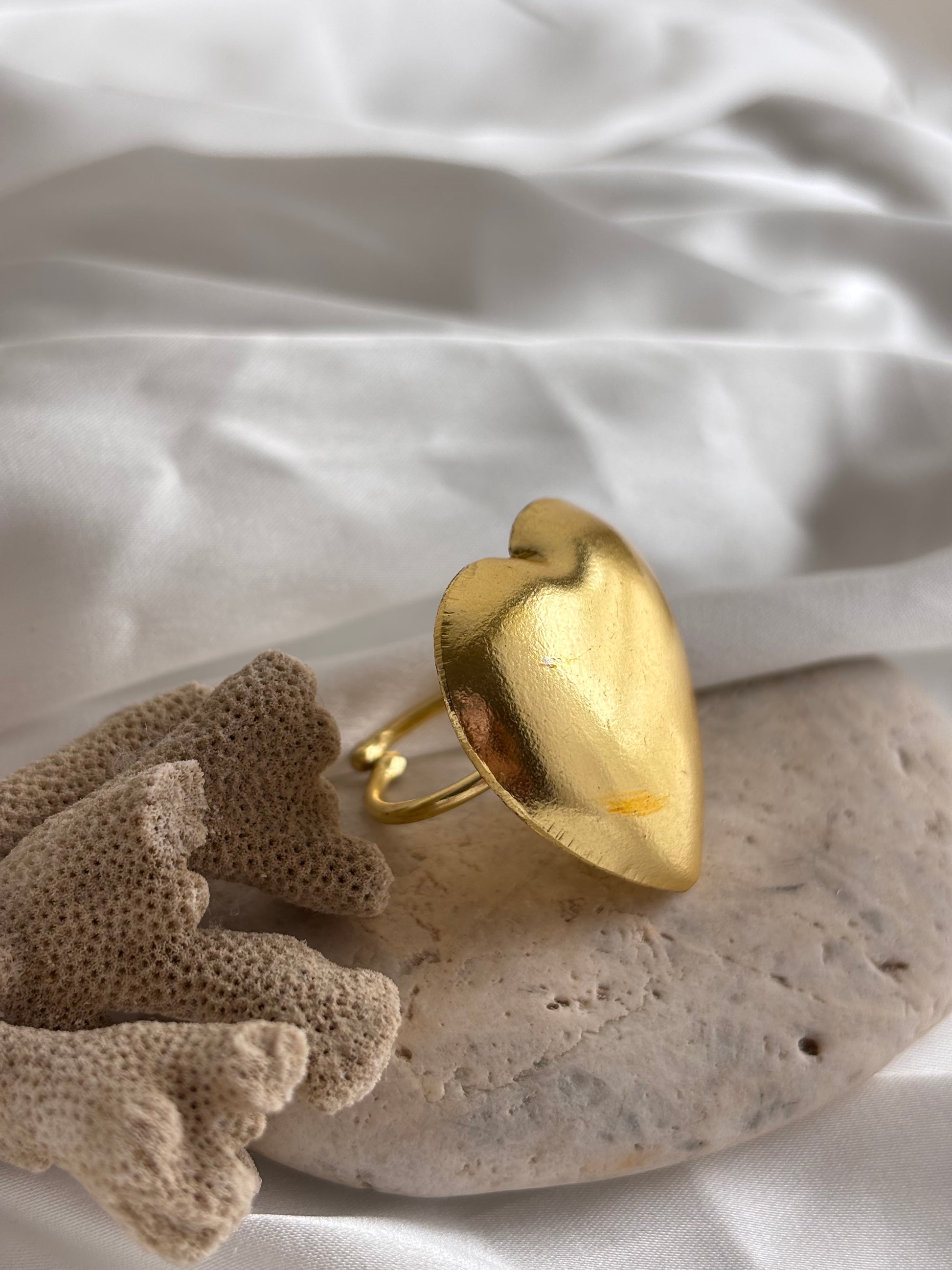 Gold ring on a stone surface with a soft white background