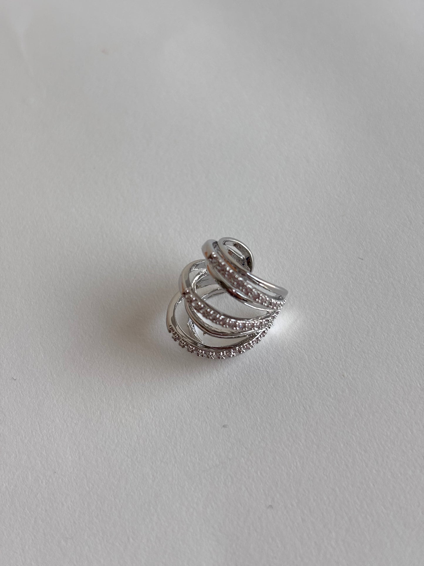 Silver ear cuff with multiple bands on a light gray background
