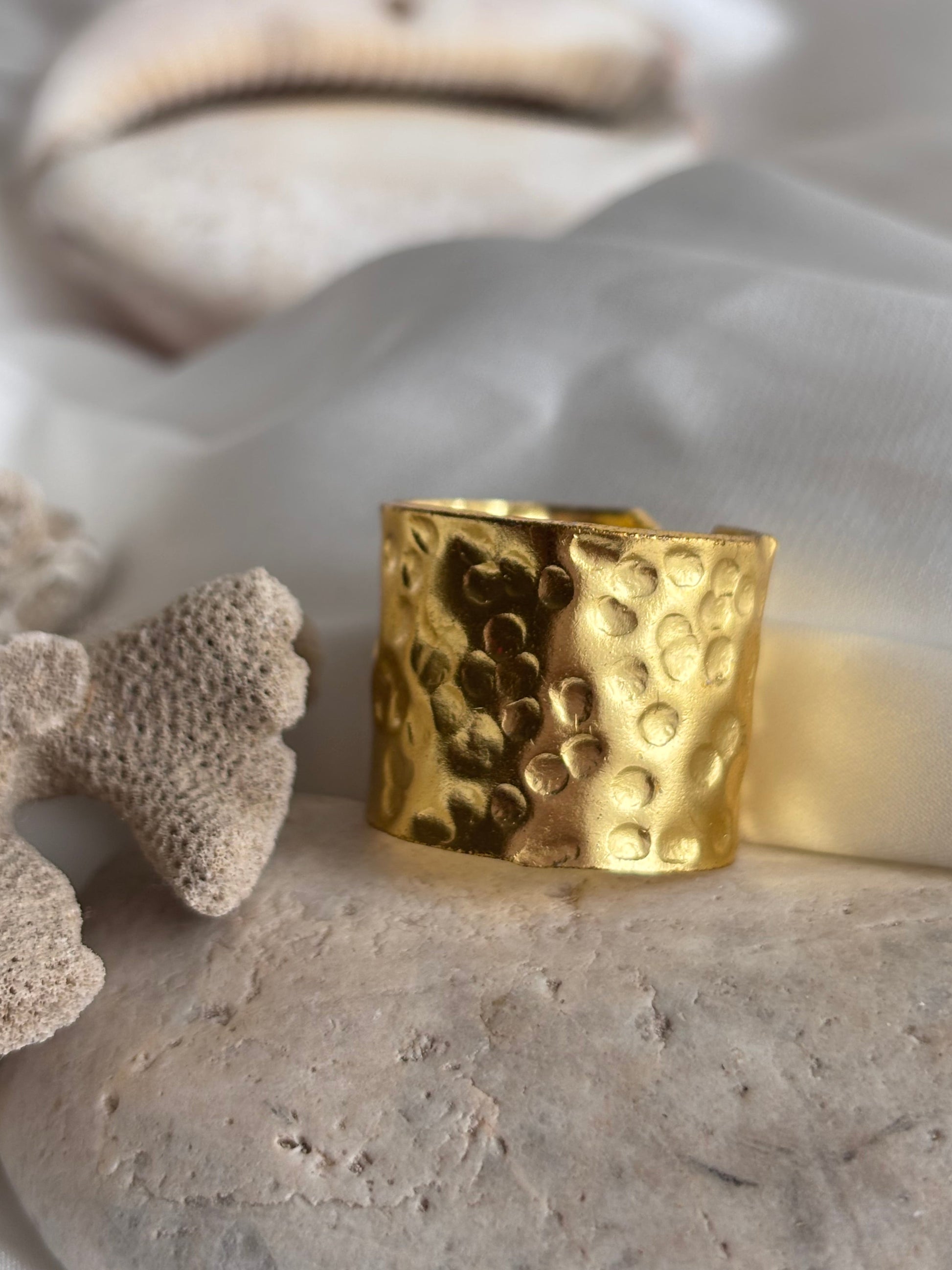 Handcrafted Gold ring with a textured band on a stone surface