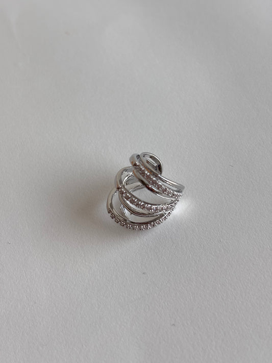 Silver ear cuff with multiple bands on a light gray background